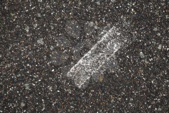 White stripe on grungy dark gray tarmac, highway road marking. Abstract transportation background texture