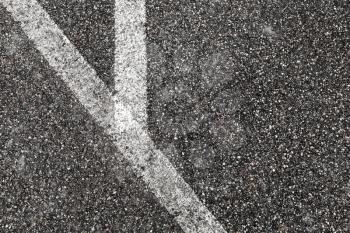 Corner of white lines on dark gray tarmac, highway road marking. Abstract transportation background texture