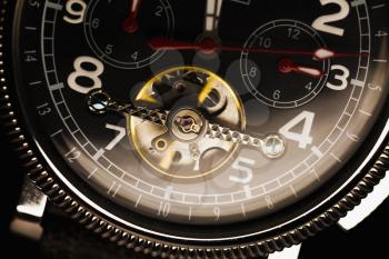 Mechanical luxury men wrist watch with automatic winding, closeup fragment of black deal