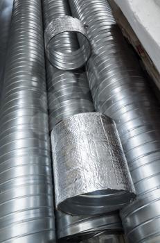 Group of shiny metallic tubes for air ventilation systems, vertical photo