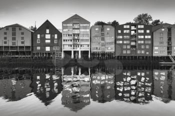 Coast of Nidelva river. Wooden houses in old town of Trondheim, Norway. Monochrome photo
