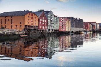 Colorful traditional wooden houses in old town of Trondheim, Norway. Coast of Nidelva river. Vintage tonal correction photo filer, old style effect