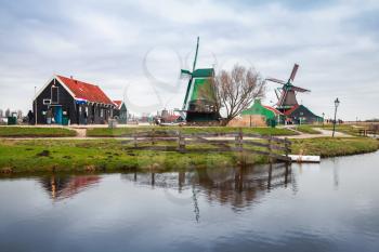 Windmills and old wooden houses on the Zaan river coast,  Zaanse Schans town is one of the popular tourist attractions of the Netherlands
