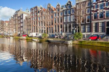 Colorful traditional houses along the canal coast in old Amsterdam, Netherlands