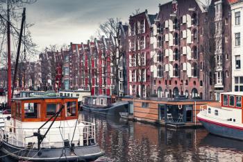 Colorful traditional living houses and houseboats along the canal in Amsterdam, Netherlands. Cold vintage tonal correction filter effect