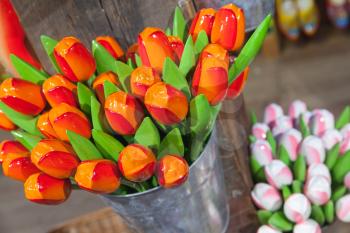 Colorful wooden tulips stand in small bucket in souvenir shop of Amsterdam, Netherlands
