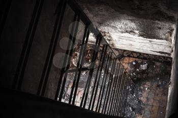 Old empty abandoned bunker interior with rusted metal ladder going down from dark room to the light
