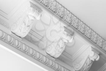 Round decorative clay stucco relief moldings with floral ornaments on white ceiling in abstract classical style interior