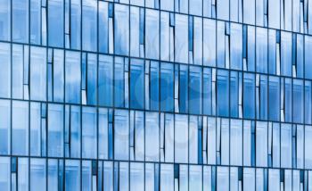 Modern office building facade, sky reflections in blue glass and steel frames