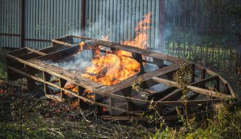 Burning wooden boat frame, outdoor bonfire