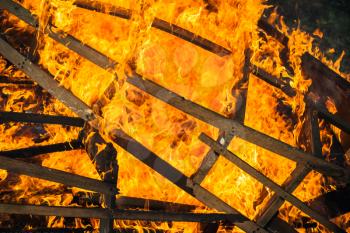 Burning wooden structure frames, outdoor bonfire background