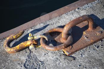 Ships mooring equipment, rusted hook mounted in concrete pier