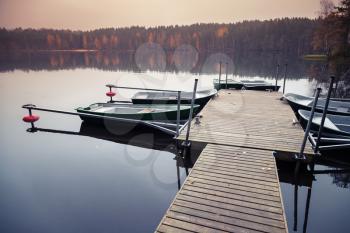 Floating pier with moored row boats, still lake landscape, Karelia, Russia