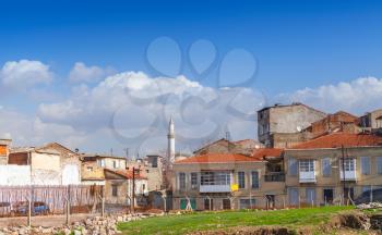 Street view of old Izmir, Turkey. Living houses and mosque under cloudy sky