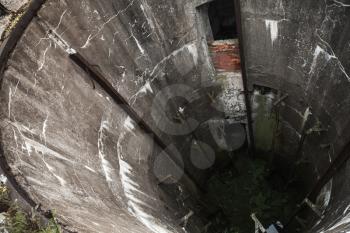 Abandoned military silo. Grunge concrete well interior