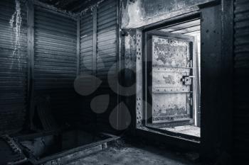 Abstract dark grungy industrial interior with metal walls and open heavy steel door, monochrome photo