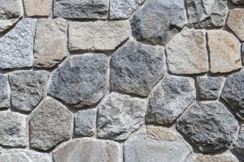 Rough outdoor gray stone wall, flat background photo texture