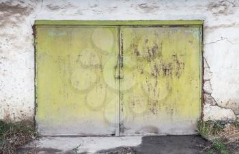 Closed rusty green gate in white concrete garage wall, flat background photo texture
