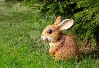 Brown rabbit toy in the green garden
