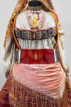 Balkan folk costume on white in museum
