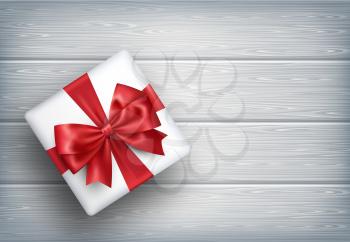 Present Gift Box with Bow on Wooden Background