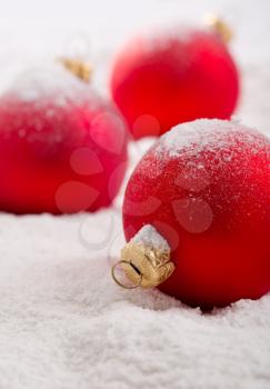 Red christmas baubles on snow