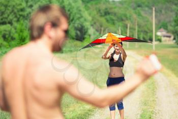 Happy couple flying a kite in a summer day
