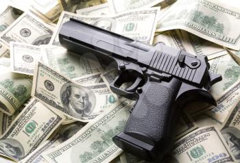 Heap of $100 dollar bills and handgun