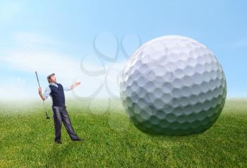 Golfer stands near a huge golf ball