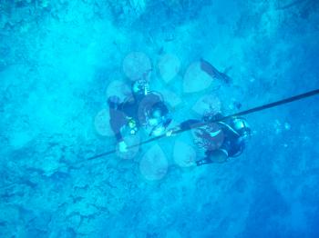 Two divers in sea abyss