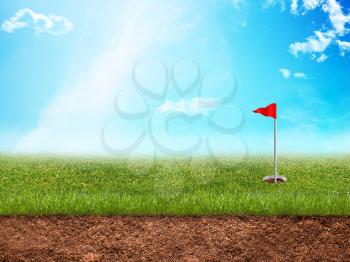 Golf hole with a red flag in grass