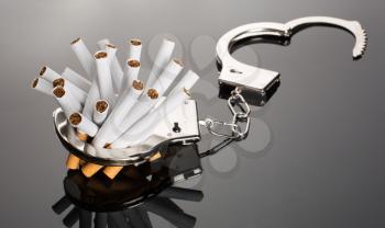 Heap of cigarettes locked to handcuffs