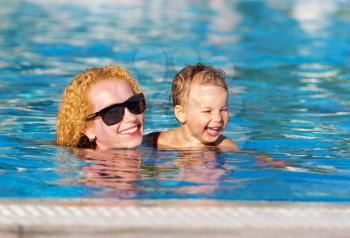 Happy mother and little daughter in the pool