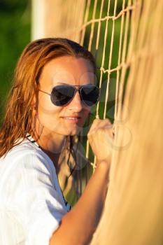 Portrait of attractive woman near volleyball net on the beach