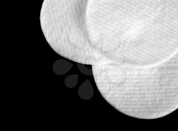 Three white hygienic cotton disks isolated on black