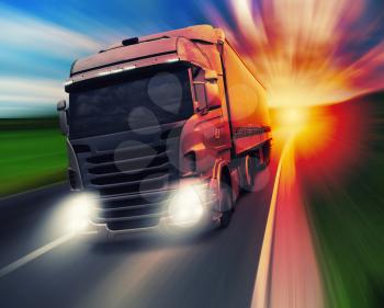 Cargo truck speeding on highway at sundown