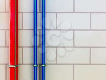 Red and blue water pipes on the wall