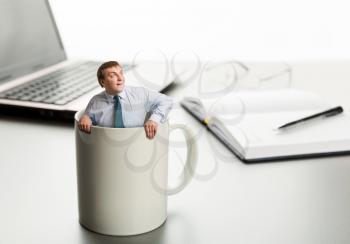 Surprised man in cup on laptop background 