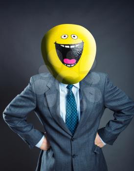 Businessman with smiley face instead of his head isolated on gray background