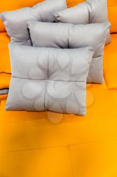 Grey pillows on a yellow bed cover