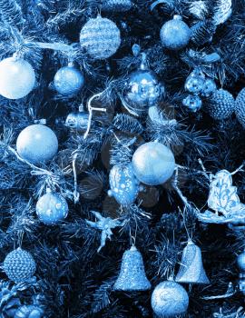 Christmas ornaments on a tree. Toned in blue. Background or texture
