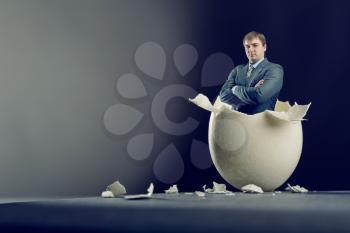 Picture of broken egg with man isolated on gray background