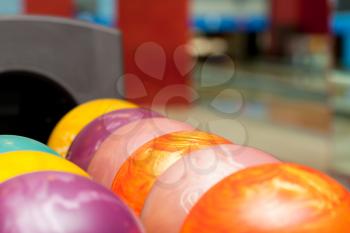 Close-up of colorful bowling balls with interior on background