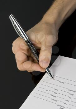 Man's hand signing the document
