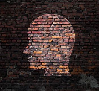 Light in form of silhouette of human head on brick wall