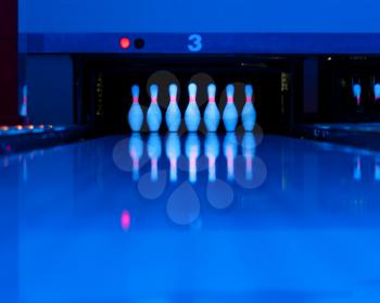 Ten bowling pins at the end of alley. Ultraviolet luminosity