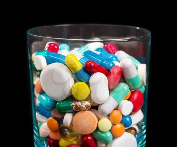 Close up of heap of many differnt pills in glass