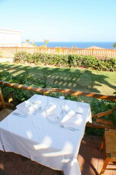 Table in outdoor resort restaurant with sea view