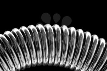 Close-up of coiled metal spring. In B/W