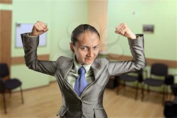 Strong woman with fists in the office